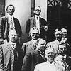 Members of town planning commission, Calgary, Alberta, ca. 1915-1916. On steps of Public Library, Central Park [Memorial Park]. L-R back row: (in doorway to right of lady) Doctor C. Stanley Mahood (Medical officer of Health for city). L-R third row: unknown; unknown; William R. Reader (right rear of Graves). L-R second row: Ike Ruttle; Arthur Graves; George Craig; unknown; Mrs. Annie Gale (in dark dress with white ruffle). L-R front row: unknown; Mayor Mike Costello; unknown; unknown; unknown;Doctor George W. Kerby.
