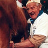 Grant MacEwan milking a cow from the book \"A Century of Grant MacEwan\"  (2002)