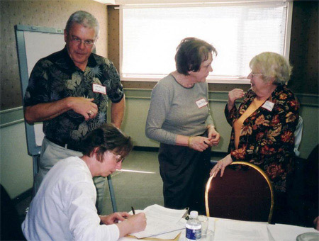 l to r: Helgi Leesment, Arne Matiisen and  Eda McClung signing the Certificate of Incorporation for the Alberta Estonian Heritage Society, April 23, 2005. Livia Kivisild is on the far right. 