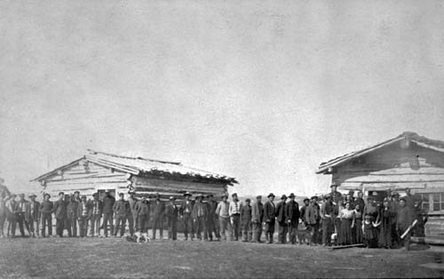 Settlers, some accompanied by members of their family, line up to purchase a homestead for the modest price of $10 CDN.  Near Grande Prairie, Alberta during the first decade of the 20th century.