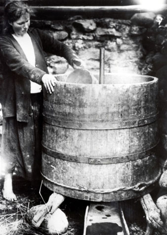 Woman attending to a cask 
for brewing beer, ca 1900.