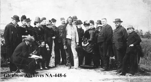 Groupe de journalistes franais visitant Poundmaker au pnitencier de Stony Mountain, Manitoba. 1886. Poundmaker, au centre; derrire lui en uniforme se trouve le gardien de prison Sam Bedson.