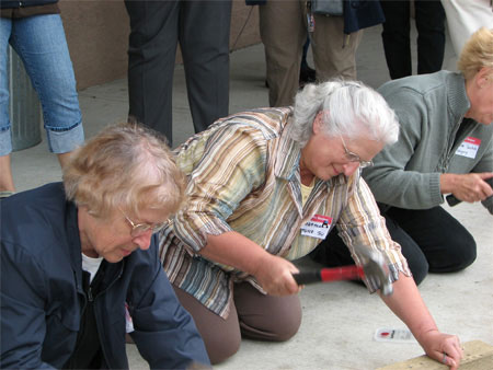 Lillian Munz and Martha Munz Gue participate in traditional   nail pounding competition at Lincoln Hall, 2007