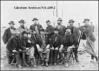 Canadian International Boundary Commission Staff, Alberta, 1872. Taken during International Boundary Survey.L-R back row: Secretary Bangs; Major W. Twining; Lieutenant Green, surveyor, unknown; unknown; unknown; unknown.L-R front row: Captain Gregory, astronomer; Colonel F. M. Farqueher, chief astronomer; Archibald Campbell, commissioner; unknown; unknown.