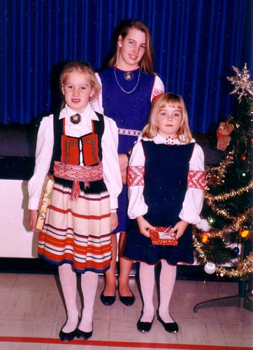 Three young Calgarians show off their colorful Estonian folk costumes during a Christmas Celebration in 1988. L to R: Erika Kivik, Krista Leesment, Milvi Tiislar
